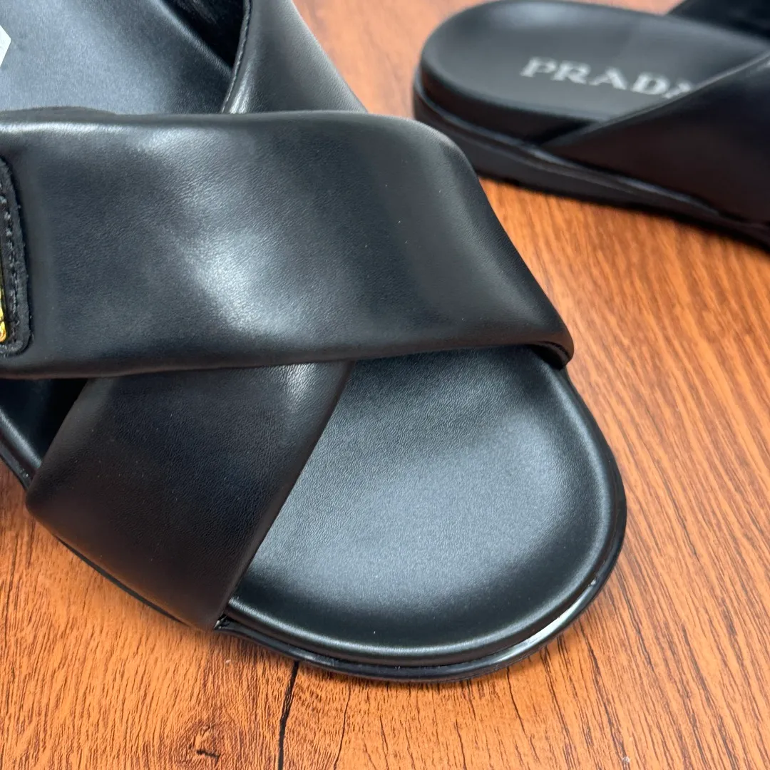 Batch 580 Prada/Prada's new men's leather cross slippers. Velcro closure can finely adjust the size. Calf leather light luxury slippers. Thick soft calf leather wraps the upper. Fat but soft rubber lazy style, soft and comfortable, excellent foot feel. Genuine leather bottom layer, cross style, with a Velcro closure buckle, easy to adjust the appropriate size, and a perfect fit for the wearing experience. The enamel gold triangle logo highlights the brand's classic features. Lightweight rubber thin sole, high foot comfort! Complete package! Size: 39-40-41-42-43-44-45 Leather shoe size Item number: 2X7132 Black